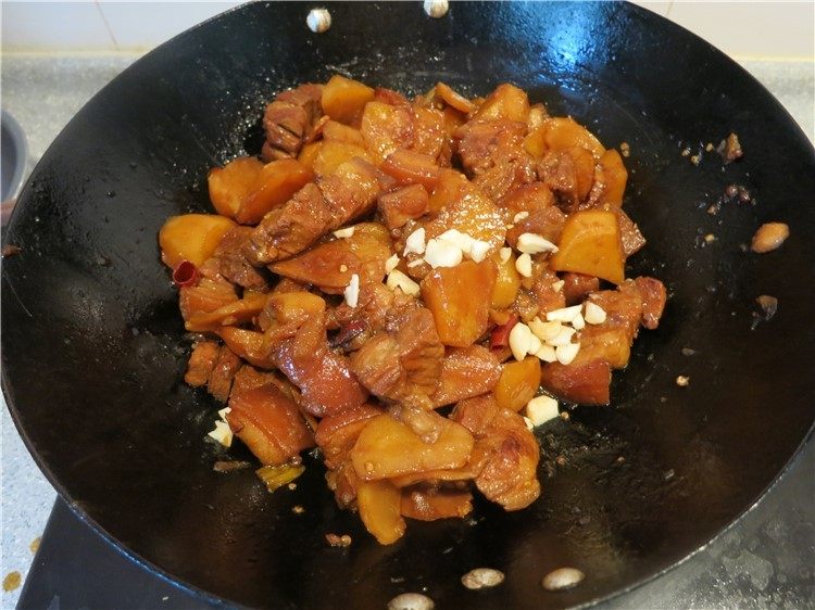 唇齿留香软糯如沙--红烧肉炖土豆,放上切碎的大蒜瓣，翻拌一下可以关火出锅了