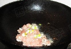 肉片杏鲍菇,肉片变色后放入葱姜碎继续翻炒均匀