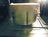 奶酥吐司,将面团取出整圆，面包桶的搅拌棒拿掉，放入整圆的面团，面包桶表面盖上一块湿布，移入烤箱内，选择发酵模式，发酵1小时
