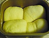 奶酥吐司,面包桶盖一块湿布，上面加盖一层保鲜膜放入烤箱内，选择发酵模式，40-60分钟，发酵至原来的1.5-2倍大