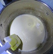 自制巧克力蛋黄派,筛入面粉，拌匀，再加入剩下的牛奶拌匀