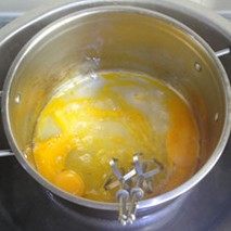 自制巧克力蛋黄派,容器中加入白糖和鸡蛋，把蛋液隔水加热到40度