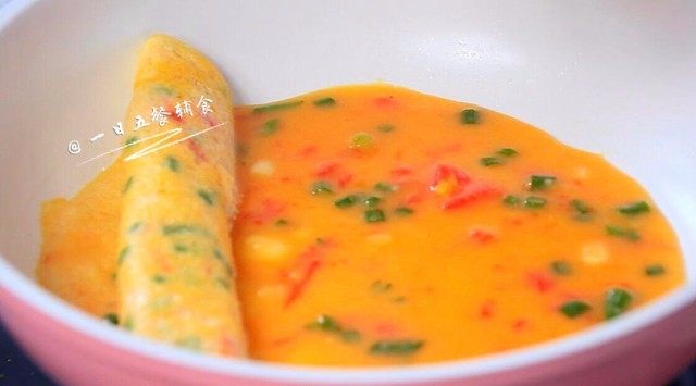 番茄土豆银鱼厚蛋烧,用铲子将蛋皮从一侧卷到另一侧，成为蛋卷。继续舀大半勺蛋液在蛋卷空位，迅速摊开。