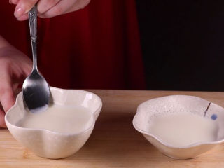 双皮奶的家常做法，香甜爽口好吃又过瘾！,用勺子在牛奶的边沿看看奶皮结好了，会挂在勺子上。