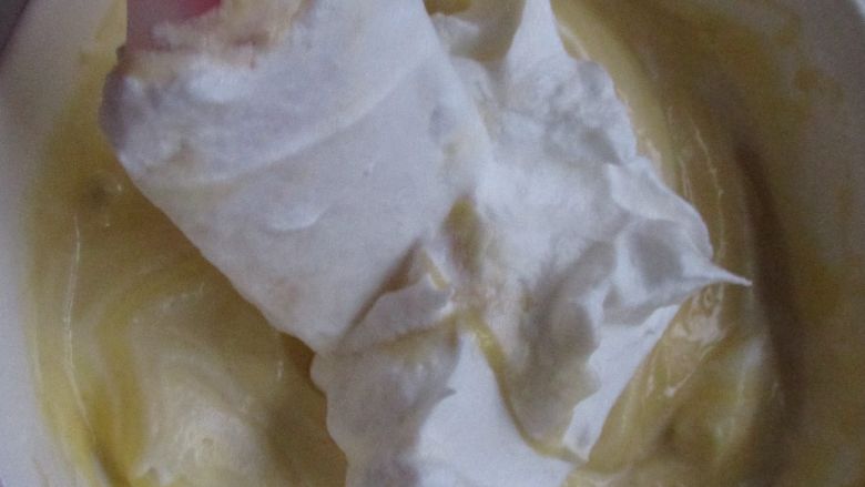 酒味慕斯蛋糕,把蛋白霜加到蛋黄糊中翻拌均匀。