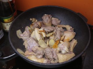 姜焖鸭,油八成热的适合倒入沥干的鸭肉和姜片、陈皮一起翻炒；