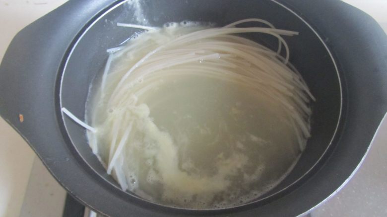 榨菜肉丝米粉,高汤煮开后下入泡软的米粉；