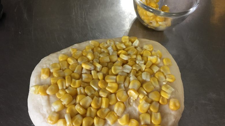 奶香玉米餐包,将玉米粒均匀揉到面团里、
（这一个步骤要用手揉来操作，不要使用机器，容易把玉米粒碾碎）