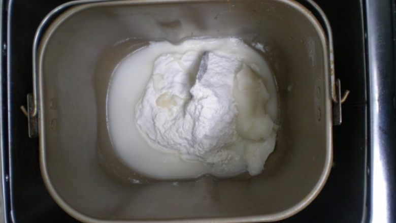 红曲粉蛋黄酥,温水倒进面包机猪油就会融化了。搅打几下把面粉和盐全部倒进去，然后设置面包机揉面程序30分钟