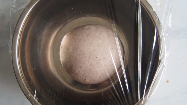 黑麦红枣核桃卷,面团放入盆中，盖上保鲜膜发酵至2倍大。