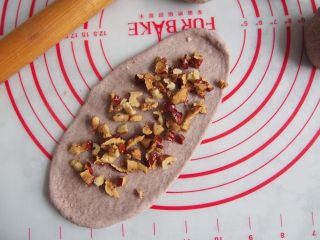 黑麦红枣核桃卷,将红枣核桃切碎，均匀铺在面饼上面，从一侧卷起，收口捏紧。