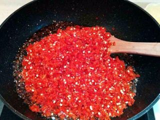 蒜蓉辣椒酱,倒入辣椒碎，继续小火煸炒出辣椒的水汽，用小火慢慢的熬，期间用锅铲不停的搅动，以免粘锅。