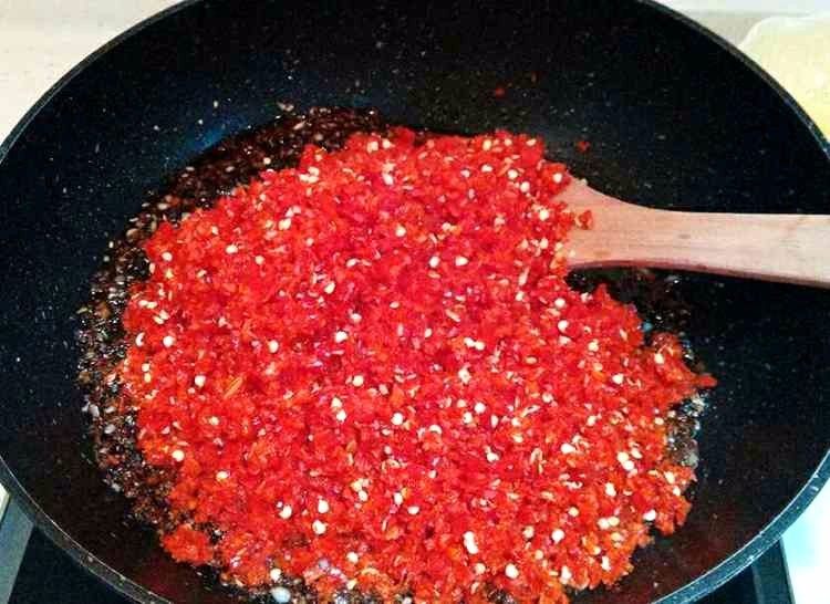 蒜蓉辣椒酱,倒入辣椒碎，继续小火煸炒出辣椒的水汽，用小火慢慢的熬，期间用锅铲不停的搅动，以免粘锅。