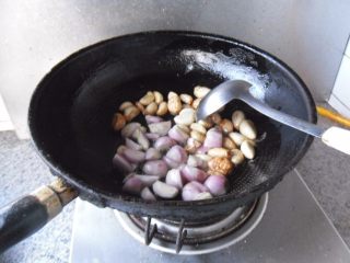 葱头大蒜烧鱿鱼, 把大蒜炒制微微发黄，放入葱头，中小火，将其炒香 