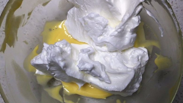 斑马纹酸奶戚风,取一半的蛋白霜加入到原味面糊中，用蛋抽快速将蛋白霜打碎，用刮刀从盆边切入至底部，翻拌均匀，切忌划圈搅拌
