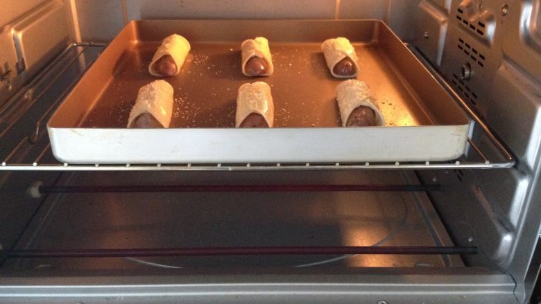 饺皮芝士烤肠,烤箱上下火200度预热5分钟，将烤盘放置在中层，烤制10分钟，芝士融化，表皮上色即可
