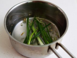 蛤蜊蒸水蛋,将小葱和生姜放入煮锅，加水大约350克和盐1克。