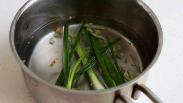 蛤蜊蒸水蛋,将小葱和生姜放入煮锅，加水大约350克和盐1克。