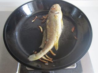 黄鱼焖豆腐,轻轻晃动下锅， 鱼能跟着动后再煎会儿翻个面将另一面也煎至金黄；