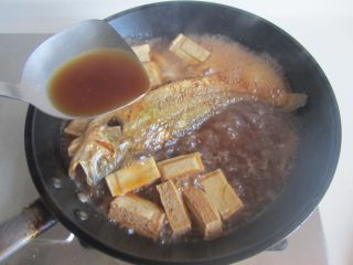 黄鱼焖豆腐,大火收汁，注意中间翻动一下鱼，将汤汁水不停地浇淋在鱼表面上；