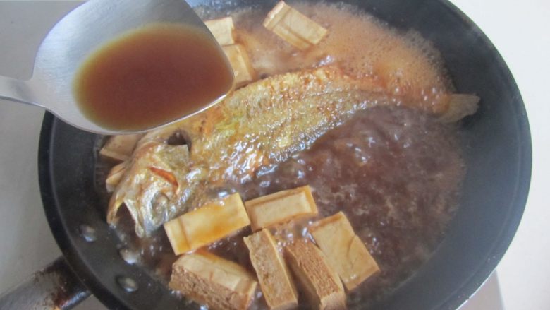 黄鱼焖豆腐,大火收汁，注意中间翻动一下鱼，将汤汁水不停地浇淋在鱼表面上；
