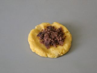 豆沙红薯软香饼,将红薯团压一压，压平后在中间放入红豆沙。