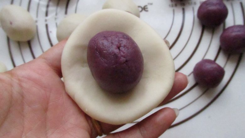 紫薯蛋黄酥,把水油皮擀开，包入紫薯油酥。