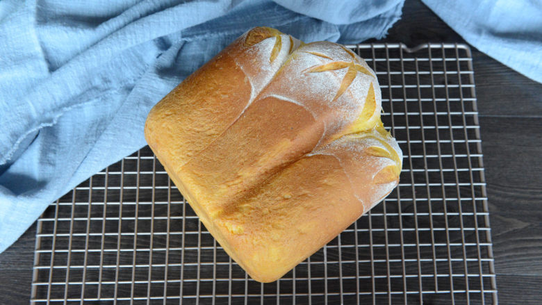 面包机版胡萝卜吐司,将面包侧着倒在晾网上晾凉。