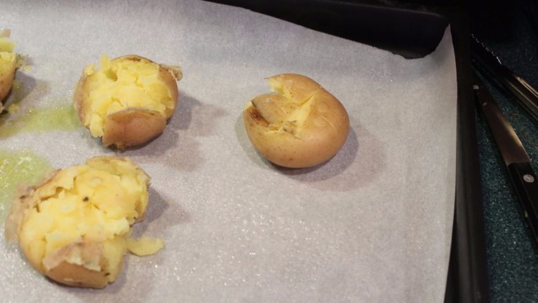 柠檬大蒜脆烤土豆,不用压的太用力，以免将土豆压碎。压好后，可以将上层的皮拨往旁边。