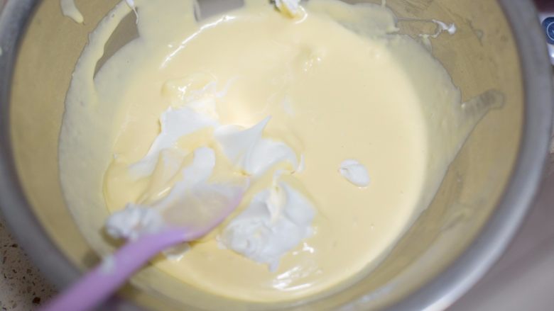 懒人食谱破壁机棉花轻乳酪,先加入1/3的蛋白翻拌，再倒入全部蛋白翻拌均匀，要兜底翻拌