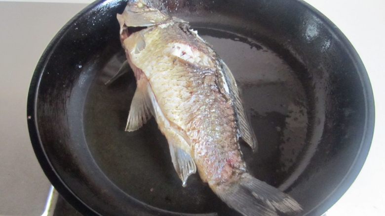 鲫鱼豆腐汤,小火慢慢煎，不要急于翻动，待快煎好后微微晃动下锅，如果鱼能跟着晃动后就可以翻面了， 翻面后再将另一面也煎至金黄；