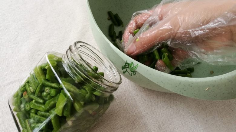 腌酸豆角懒人法,被盐揉过的豆角变更绿，装在瓶子里，盖紧盖子（漏气会坏）。