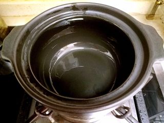 香肠砂锅煲仔饭,往砂锅里倒入一点植物油，用小刷子把砂锅的内部都刷上植物油。