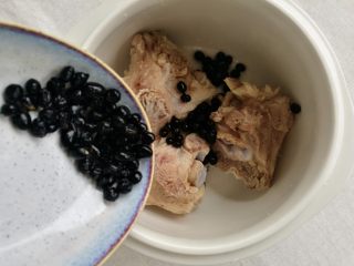 山药黑豆滋补汤,洗净的排骨和黑豆放入隔水炖锅中。