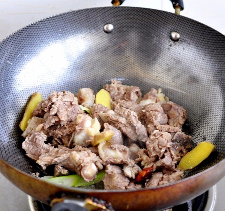 土豆炖牛仔骨,加入牛仔骨，慢炒出水分，肉炒至微黄即可。