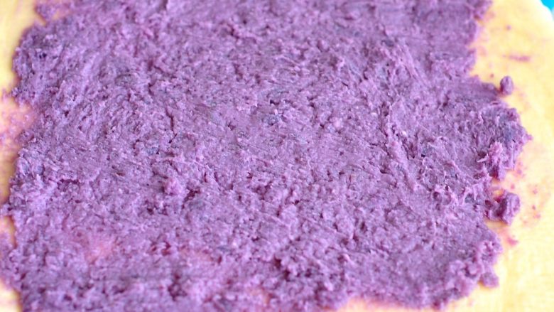 紫薯辫子土司,把紫薯泥平铺在面皮上，抹均匀。
