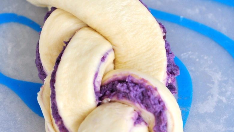 紫薯辫子土司,利用编辫子的方法，把面团折叠编好，把底部捏紧封口，移到土司盒中。