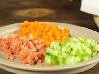 黄金蛋炒饭！让你爱上吃饭！,将胡萝卜、黄瓜、火腿肠切成碎粒 ，放至盘中备用