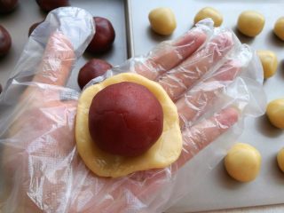 广式蛋黄月饼,取一个小剂子按扁包住馅料。