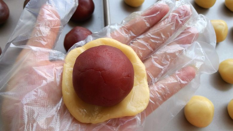 广式蛋黄月饼,取一个小剂子按扁包住馅料。