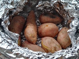 坤博砂锅烤红薯,中大火烤30分钟后把红薯翻一面（用馒头夹翻面防烫，看已经有裂口快熟了，用筷子扎稍微有点硬）。红薯翻面转中火继续烤。
