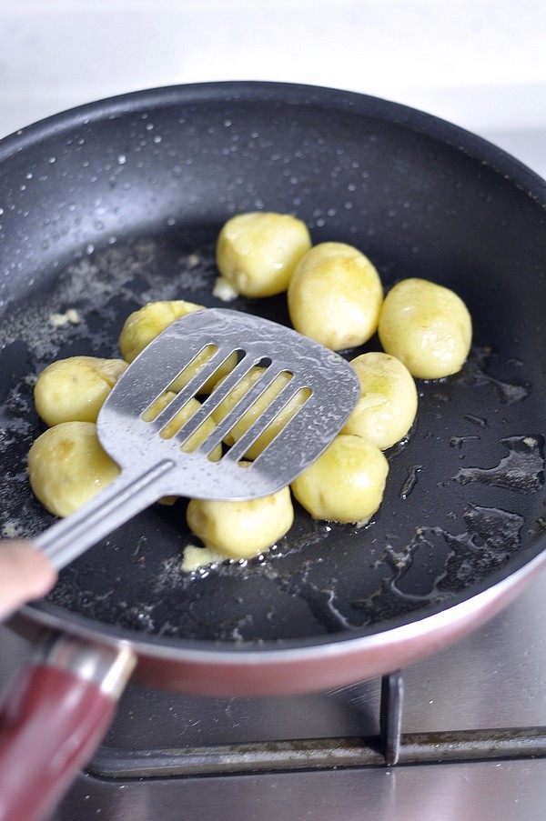 香煎孜然小土豆,用炒勺把土豆稍按压至扁。