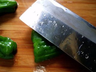 糖醋虎皮椒,每个用刀背稍用劲压一压，表面裂开不断，方便煎时均匀受热