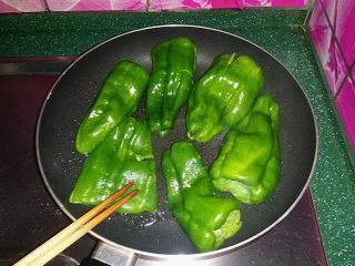 糖醋虎皮椒,用筷子（或锅铲）轻轻按压青椒并不时翻面，使之均匀受热