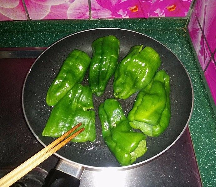 糖醋虎皮椒,用筷子（或锅铲）轻轻按压青椒并不时翻面，使之均匀受热