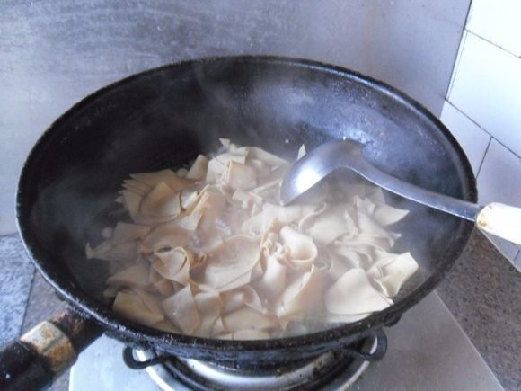干豆腐黄瓜片, 炒匀后加水，小火烧制2分钟 