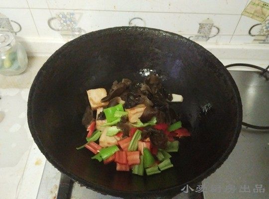 孜然鱼豆腐,下入青红椒、木耳翻炒。