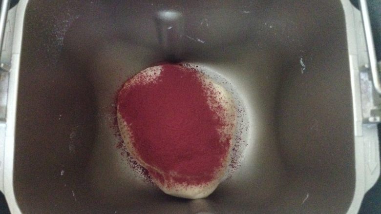 玫瑰花面包,取其中一份再次放入面包机桶内，倒入红曲粉揉面10分钟