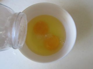 蛋抱香肠年糕,鸡蛋打入碗中， 加入适量的盐打散；