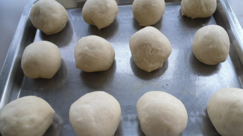 瓜子仁面包, 然后将其团圆，摆入烤盘。覆盖保鲜膜二次发酵 